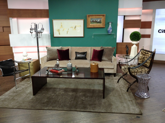 A sitting area of the TV show with sofa and chairs