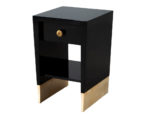 Small black lacquer nightstand with gold-toned bases and single drawers, ideal for contemporary bedroom interiors.